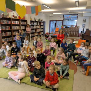 Przedszkolaki na zajęciach bibliotecznych w Bibliotece Publicznej w Brzesku. Dzieci siedzą na dywanie i słuchają czytanej książki. Kliknięcie na zdjęcie spowoduje jego powiększenie do rozmiaru oryginalnego.