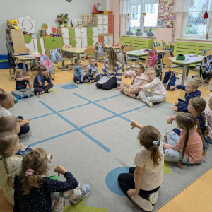 Przedszkolaki siedzą na dywanie uczestniczą w warsztatach z panią psycholog dotyczących przyjaźni. Kliknięcie na zdjęcie spowoduje jego powiększenie do rozmiaru oryginalnego.
