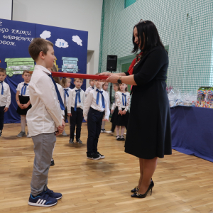 Pasowanie na ucznia klasy pierwszej przez panią Dyrektor Joannę Ozorkę-Krawczyk. Kliknięcie na zdjęcie spowoduje jego powiększenie do rozmiaru oryginalnego.