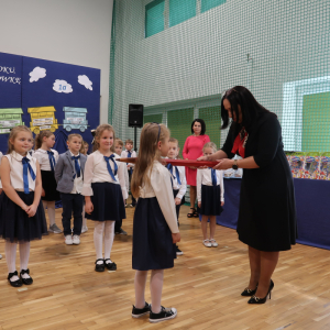 Pani Dyrektor Joanna Ozorka-Krawczyk pasuje na ucznia jedno z pierwszaków. Kliknięcie na zdjęcie spowoduje jego powiększenie do rozmiaru oryginalnego.