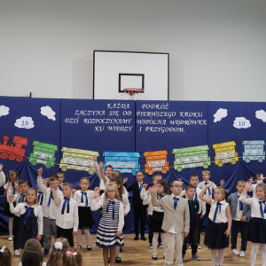 Pierwszaki unosza ręce do góry - prezentują przygotowany taniec. Kliknięcie na zdjęcie spowoduje jego powiększenie do rozmiaru oryginalnego.