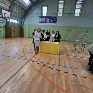 Pani Dyrektor Joanna Ozorka-Krawczyk wraz z nauczycielami z grupy żółtej stoi przy stoliku z puzzlami. Kliknięcie na zdjęcie spowoduje jego powiększenie do rozmiaru oryginalnego.