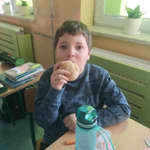 Uczeń je upieczoną bułeczkę. Kliknięcie na zdjęcie spowoduje jego powiększenie do rozmiaru oryginalnego.