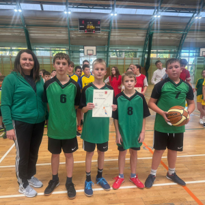 Uczniowie ubrani w stroje sportowe z dyplomem za zajęte miejsce. Kliknięcie na zdjęcie spowoduje jego powiększenie do rozmiaru oryginalnego.