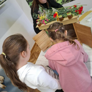 Dziewczynki oglądają żywe pszczoły umieszczone w przenośnym ulu edukacyjnym. Kliknięcie na zdjęcie spowoduje jego powiększenie do rozmiaru oryginalnego.