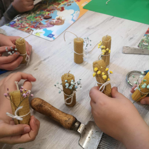 Dzieci wykonują świeczki z wosku pszczelego w ramach spotkania z pszczelarzem. Kliknięcie na zdjęcie spowoduje jego powiększenie do rozmiaru oryginalnego.