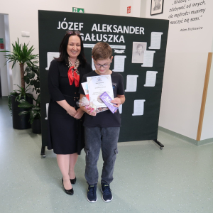 Arkadiusz Cierniak z kl. 7 b  - wyróżniony w Szkolnym Konkursie Recytatorskim Poezji Józefa Aleksandra Gałuszki z panią Dyrektor Joanną Ozorką-Krawczyk. W tle tematyczna dekoracja o poecie. Kliknięcie na zdjęcie spowoduje jego powiększenie do rozmiaru oryginalnego.