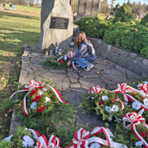 Uczennica składa wieniec przygotowany przez Szkolne Koło Wolontariuszy. Kliknięcie na zdjęcie spowoduje jego powiększenie do rozmiaru oryginalnego.