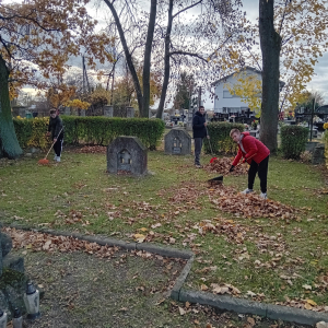 Uczniowie w trakcie grabienia liści na cmentarzu. Kliknięcie na zdjęcie spowoduje jego powiększenie do rozmiaru oryginalnego.