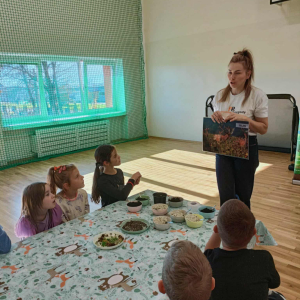Pani opowiada uczniom o lesie, zwierzętach w trakcie warsztatów. Kliknięcie na zdjęcie spowoduje jego powiększenie do rozmiaru oryginalnego.