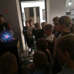 Uczniowie obserwują kulę elektrostatyczną w Muzeum Iluzji. Kliknięcie na zdjęcie spowoduje jego powiększenie do rozmiaru oryginalnego.