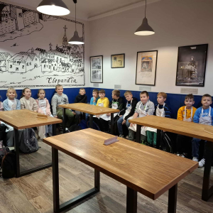 Uczniowie klas 3 siedzą na ławeczkach w Muzeum Ilulzji w Krakowie. Kliknięcie na zdjęcie spowoduje jego powiększenie do rozmiaru oryginalnego.