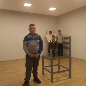 Iluzja wielkości - na pierwszym planie uczeń w tle reszta dzieci na krześle, które zaburza iluzję wielkości. Kliknięcie na zdjęcie spowoduje jego powiększenie do rozmiaru oryginalnego.