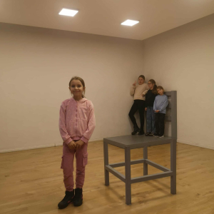 Złudzenie optyczne - na pierwszym planie uczennica klasy 3 w tle inni uczniowie na krzesełku. Kliknięcie na zdjęcie spowoduje jego powiększenie do rozmiaru oryginalnego.