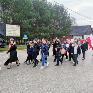 Przemarsz Dyrekcji, nauczycieli i uczniów z transparentami i flagami w trakcie obchodów Dnia Niepodległości.  Kliknięcie na zdjęcie spowoduje jego powiększenie do rozmiaru oryginalnego.