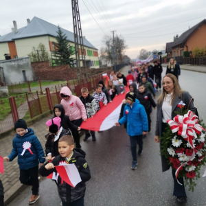 Uczniowie niosą flagę Polski na Marszu Niepodległości.  Kliknięcie na zdjęcie spowoduje jego powiększenie do rozmiaru oryginalnego.