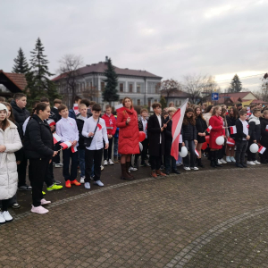 Nauczyciele i uczniowie wokół pomnika ofiar 2 wojny światowej zgromadzeni w ramach obchodów Dnia Niepodległości.  Kliknięcie na zdjęcie spowoduje jego powiększenie do rozmiaru oryginalnego.