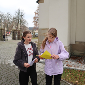 Uczennice ZS w Szczurowej przy kościele w trakcie rozwiązywania jednego z zadań. Kliknięcie na zdjęcie spowoduje jego powiększenie do rozmiaru oryginalnego.