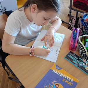 Uczennica rozwiązuje przykłady z tabliczki mnożenia. Kliknięcie na zdjęcie spowoduje jego powiększenie do rozmiaru oryginalnego.