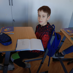 Uczeń z otwartym zeszytem z matematyki uczestniczy w akcji związanej z utrwalaniem tabliczki mnożenia. Kliknięcie na zdjęcie spowoduje jego powiększenie do rozmiaru oryginalnego.