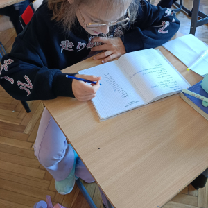 Utrwalanie tabliczki przez jedną z uczennic. Kliknięcie na zdjęcie spowoduje jego powiększenie do rozmiaru oryginalnego.