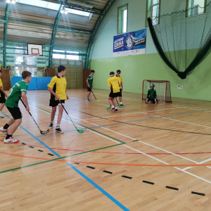 Uczniowie grają w unihokeja na sali. Kliknięcie na zdjęcie spowoduje jego powiększenie do rozmiaru oryginalnego.