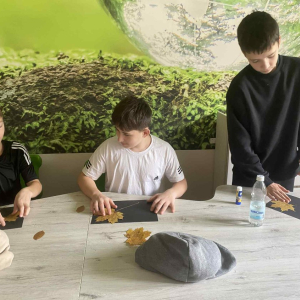 Młodzież w trakcie wykonywania prac plastycznych z liśćmi w trakcie spotkania z leśnikiem i dendrologiem. Kliknięcie  na zdjęcie spowoduje jego powiększenie do rozmiaru oryginalnego.