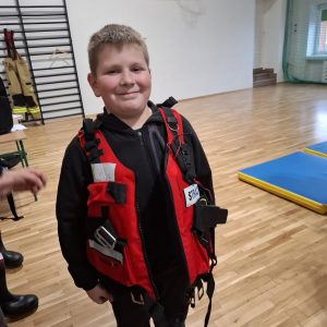 Uczeń klasy 3 w czerwonej kamizelce strażackiej. Kliknięcie na zdjęcie spowoduje jego powiększenie do rozmiaru oryginalnego.