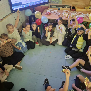 Uczniowie klasy 3 b siedzą w kole, trzymają balony. Dzieci biorą udział w zabawach andrzejkowych. Kliknięcie na zdjęcie spowoduje jego powiększenie do rozmiaru oryginalnego.