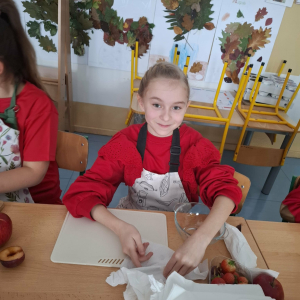 Uczennica klasy 3 a w trakcie przygotowywania sałatki owocowej. Kliknięcie na zdjęcie spowoduje jego powiększenie do rozmiaru oryginalnego.