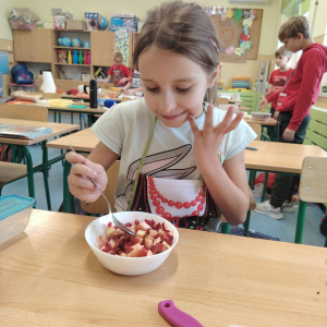 Jedna z dziewczynek próbuje przygotowaną przez siebie sałatkę owocową. Kliknięcie na zdjęcie spowoduje jego powiększenie do rozmiaru oryginalnego.