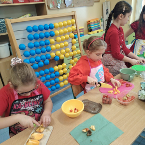 Uczniowie klasy 3 a kroją jabłka do sałatki owocowej w ramach obchodów dnia na czerwono. Kliknięcie na zdjęcie spowoduje jego powiększenie do rozmiaru oryginalnego.