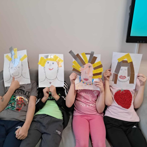 Uczniowie z papierowymi twarzami wykonanymi na zajęciach. Kliknięcie na zdjęcie spowoduje jego powiększenie do rozmiaru oryginalnego.