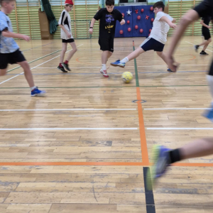 Szóstoklasiści grają w piłkę nożną na hali sportowej. Kliknięcie na zdjęcie spowoduje jego powiększenie do rozmiaru oryginalnego.
