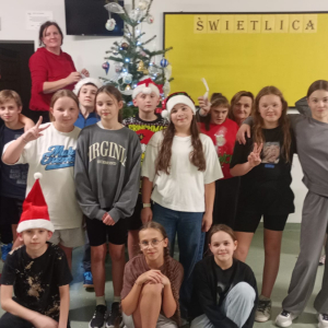 Uczniowie z klas 6 zgromadzeni przed szkolną choinką. Kliknięcie na zdjęcie spowoduje jego powiększenie do rozmiaru oryginalnego.