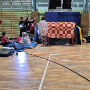 Dzieci z klas 6 w siedzą na materacach. Uczniowie nocują w szkole. Kliknięcie na zdjęcie spowoduje jego powiększenie do rozmiaru oryginalnego.