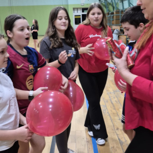 Dmuchanie balonów na hali gimnastycznej przez szóstoklasistów. Kliknięcie na zdjęcie spowoduje jego powiększenie do rozmiaru oryginalnego.