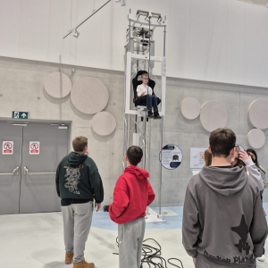 Uczeń klasy 7 siedzi na krzesełku, które dzięki sterowaniu jeździ w górę i dół. Kliknięcie na zdjęcie spowoduje jego powiększenie do rozmiaru oryginalnego.