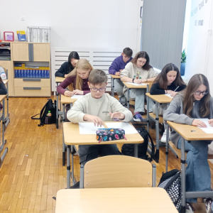 Uczniowie siedzą przy ławkach, piszą na kartkach esej z okazji obchodów 170 rocznicy śmierci Adama Mickiewicza. Kliknięcie na zdjęcie spowoduje jego powiększenie do rozmiaru oryginalnego.