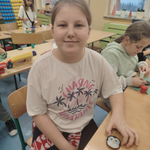 Uczennica klasy 3 a z drewnianą bombką wykonaną przez siebie. Klikniecie na zdjęcie spowoduje jego powiększenie do rozmiaru oryginalnego.