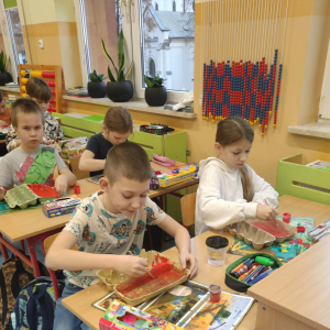 Uczniowie wykonują krokodyle z pudełek na jajka. Klikniecie na zdjęcie spowoduje jego powiększenie do rozmiaru oryginalnego.