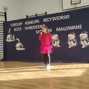 Iwona Rosa z kl. 3 a - laureatka 3 miejsca recytuje wiersz na konkursie. Kliknięci na zdjęcie spowoduje jego powiększenie do rozmiaru oryginalnego. 