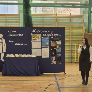 Pani Dyrektor Joanna Ozorka-Krawczyk przemawia na hali sportowej do nauczycieli,. laureatów i uczestników konkursów zwiazanych z obchodami 170 rocznicy śmierci Adama Mickiewicza. Kliknięcie na zdjęcie spowoduje jego powiększenie do rozmiaru oryginalnego.