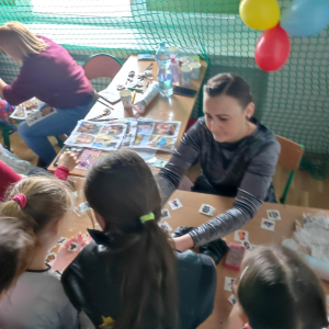 Mamy wykonują tatuaże i malują twarze dzieci w trakcie zabawy karnawałowej. Kliknięcie na zdjęcie spowoduje jego powiększenie do rozmiaru oryginalnego.