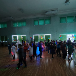 Uczniowie w grupkach tańczą na zabawie karnawałowej. Kliknięcie na zdjęcie spowoduje jego powiększenie do rozmiaru oryginalnego.