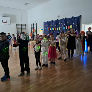 Uczniowie klas 3 stoją w szeregu, wykonują taniec na zabawie. Kliknięcie na zdjęcie spowoduje jego powiększenie do rozmiaru oryginalnego.