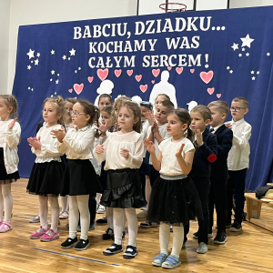 Przedszkolaki  prezentują część artystyczną zgromadzonym dziadkom.  Kliknięcie na zdjęcie spowoduje jego powiększenie do rozmiaru oryginalnego.