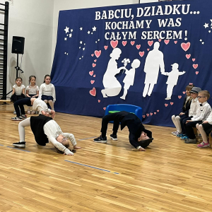 Dwójka przedszkolaków prezentuje figury akrobatyczne dla zgromadzonych dziadków.  Kliknięcie na zdjęcie spowoduje jego powiększenie do rozmiaru oryginalnego.