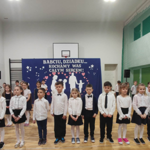 Uczniowie klas 2 ubrani w galowe stroje występują dla dziadków. Kliknięcie na zdjęcie spowoduje jego powiększenie do rozmiaru oryginalnego.