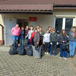 Pani Justyna Solak wraz z uczniami klasy 5 a z workami zebranych śmieci przed świetlicą w Rząchowej. Kliknięcie na zdjęcie spowoduje jego powiększenie do rozmiaru oryginalnego.